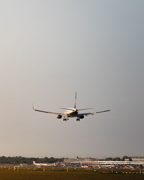 Free A commercial airplane approaches landing at sunset, showcasing aviation at Hamburg Airport. Stock Photo