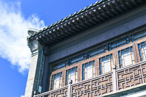 Free Low-angle view of traditional Asian building with wooden details against a clear blue sky. Stock Photo
