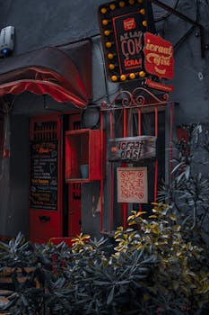 Charming entrance of a cafe with vibrant red decor and a blackboard menu.