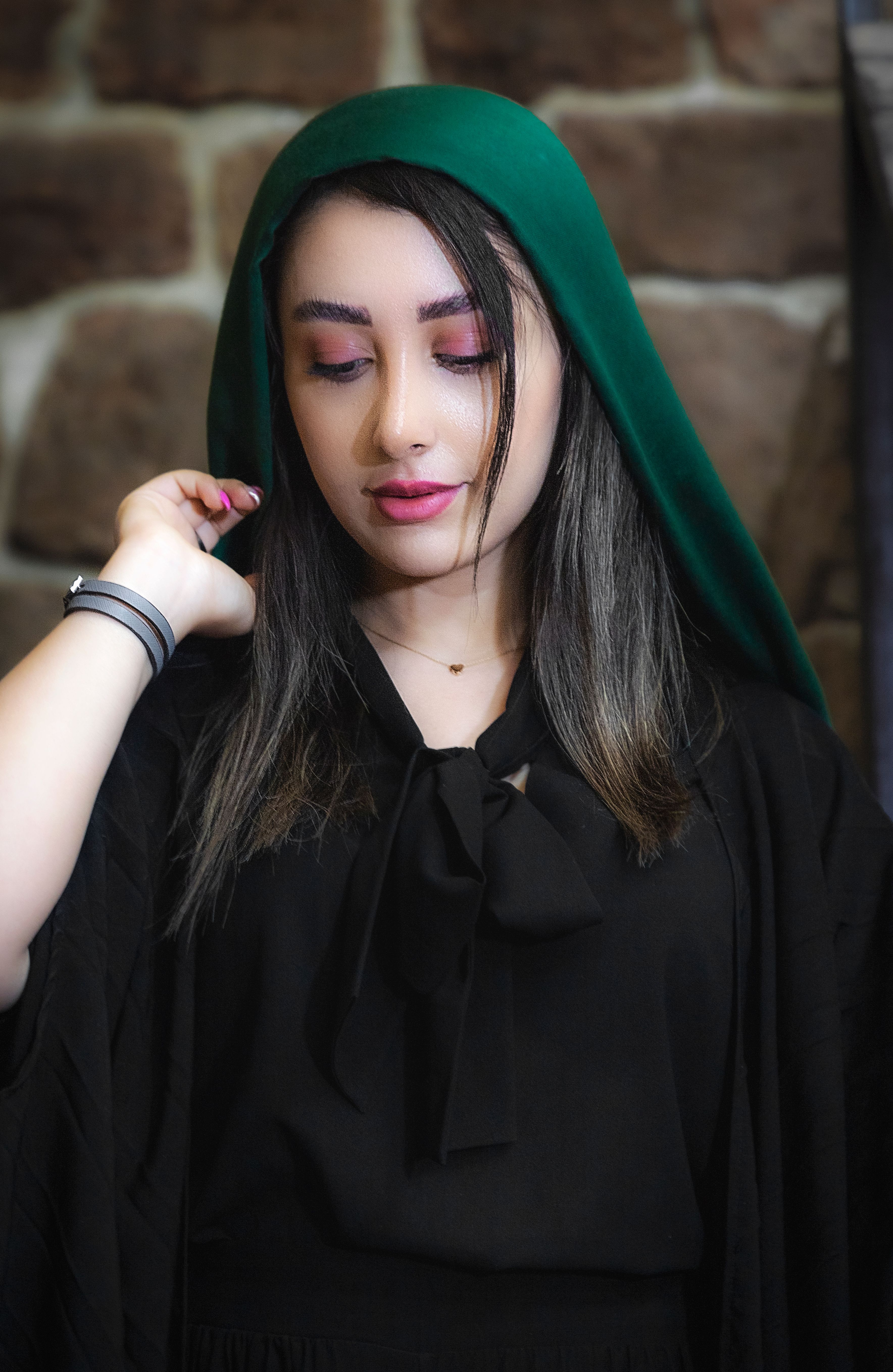 Portrait of a woman wearing a green headscarf, showcasing elegance and style in a modern fashion setting.