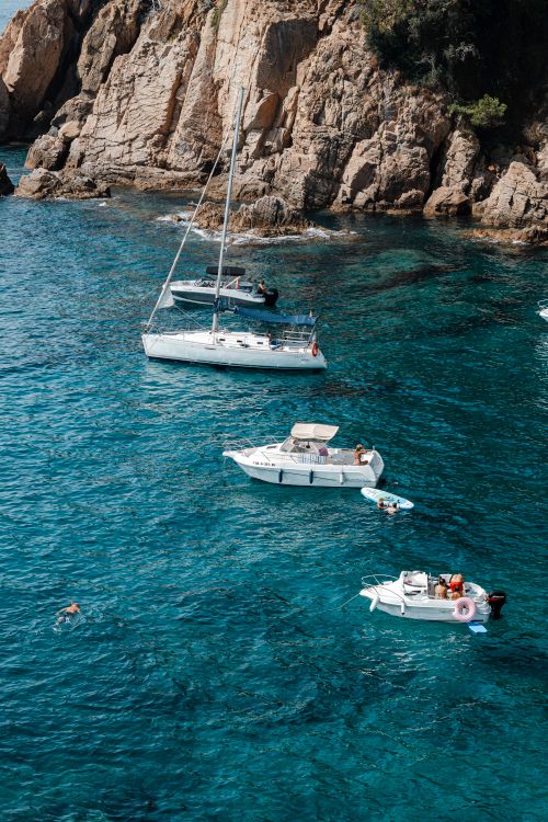 Free Aerial shot of boats near rocky cliffs in turquoise water, perfect for travel and vacation themes. Stock Photo