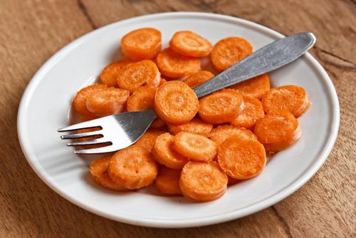 Free Close-up of fresh carrot slices on a white plate with fork, emphasizing healthy eating. Stock Photo