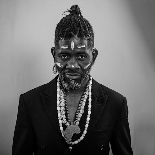 Grayscale Photo of a Man with Necklaces