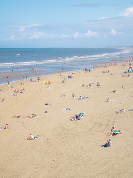 A vibrant summer beach scene with people enjoying the sun and sea.