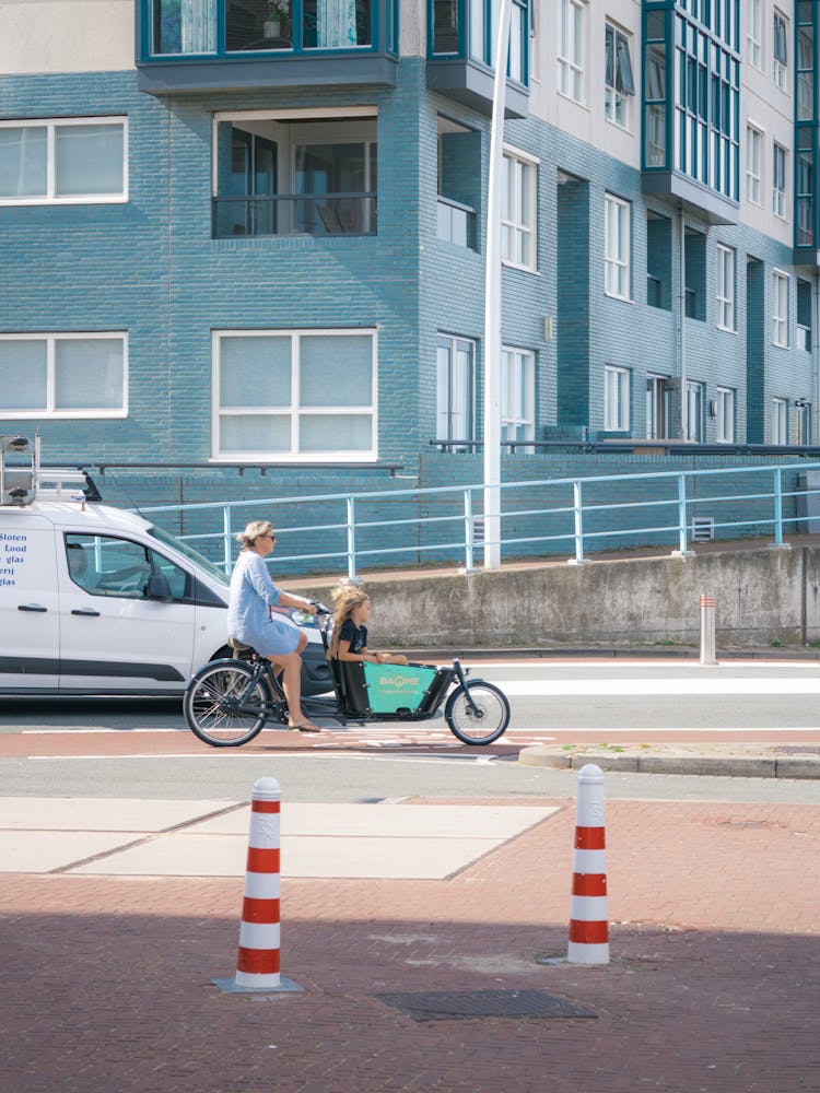 Women Riding On A Bicycle Strolling On The Road