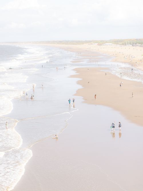 Free Aerial view of people leisurely enjoying the expansive sandy shores of Scheveningen Beach on a sunny day. Stock Photo