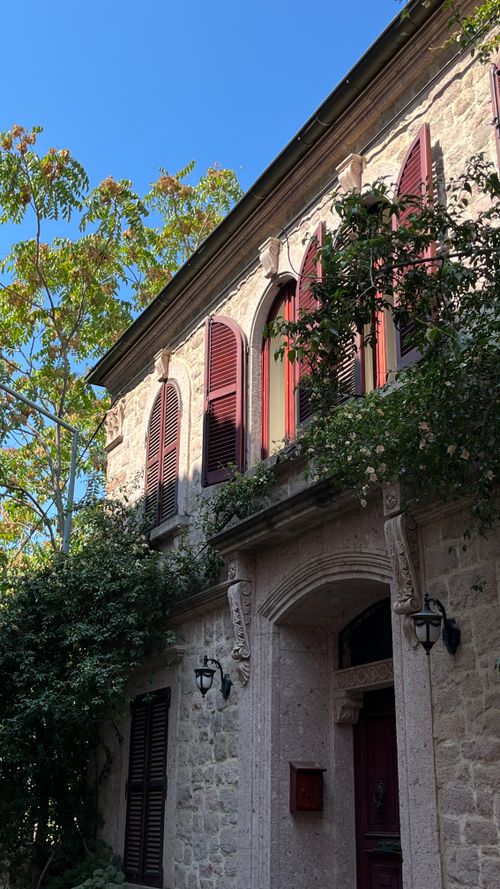 Free Charming stone house in Ayvalık, Türkiye, showcasing traditional architecture with lush greenery. Stock Photo