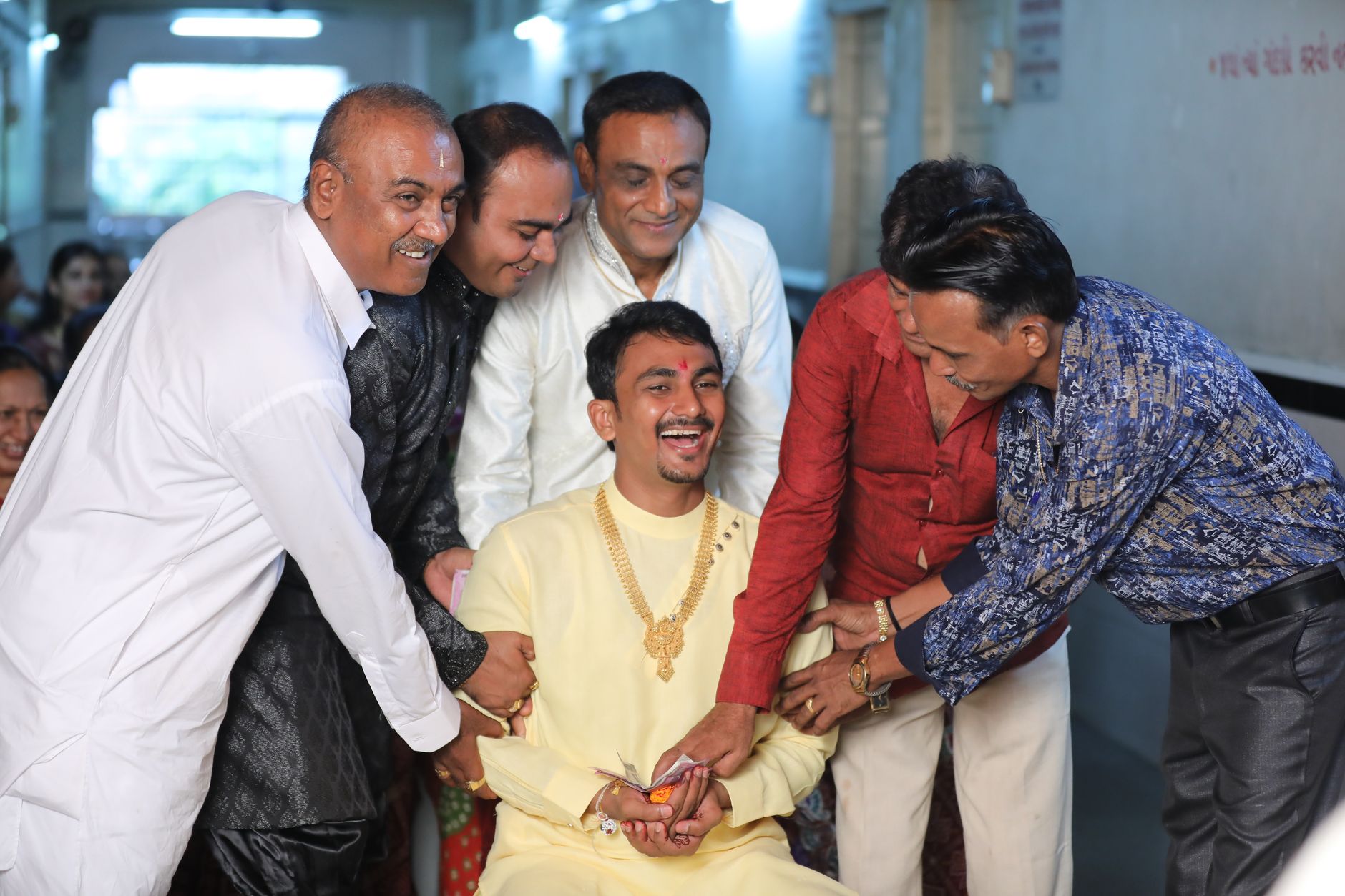 Group of Indian men joyfully celebrating indoors, capturing happiness and friendship.