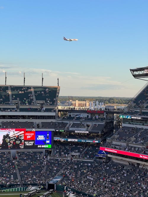 Airplane Flying in the Sky Over Stadium