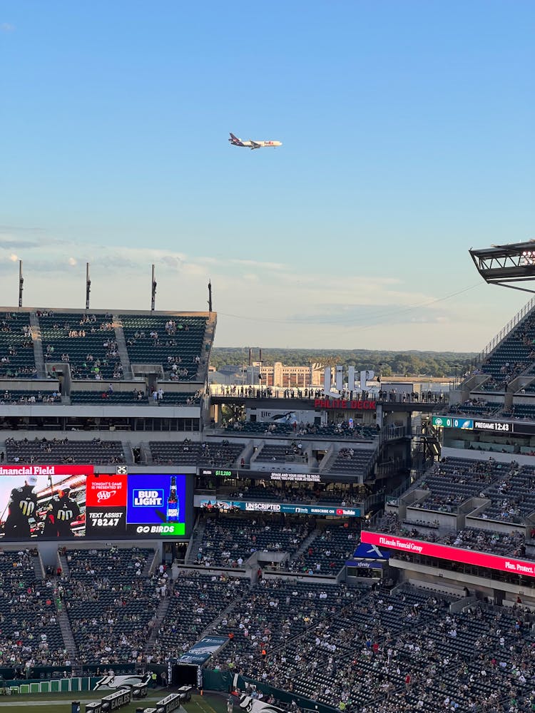 Airplane Flying In The Sky Over Stadium