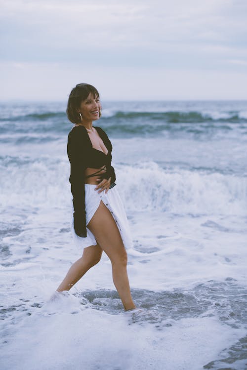 Woman Walking Ankles Deep in Water and Smiling 