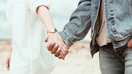 Close-Up Shot of a Romantic Couple Holding Hands Together