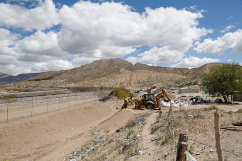 Excavator near Fence and Dirt Road