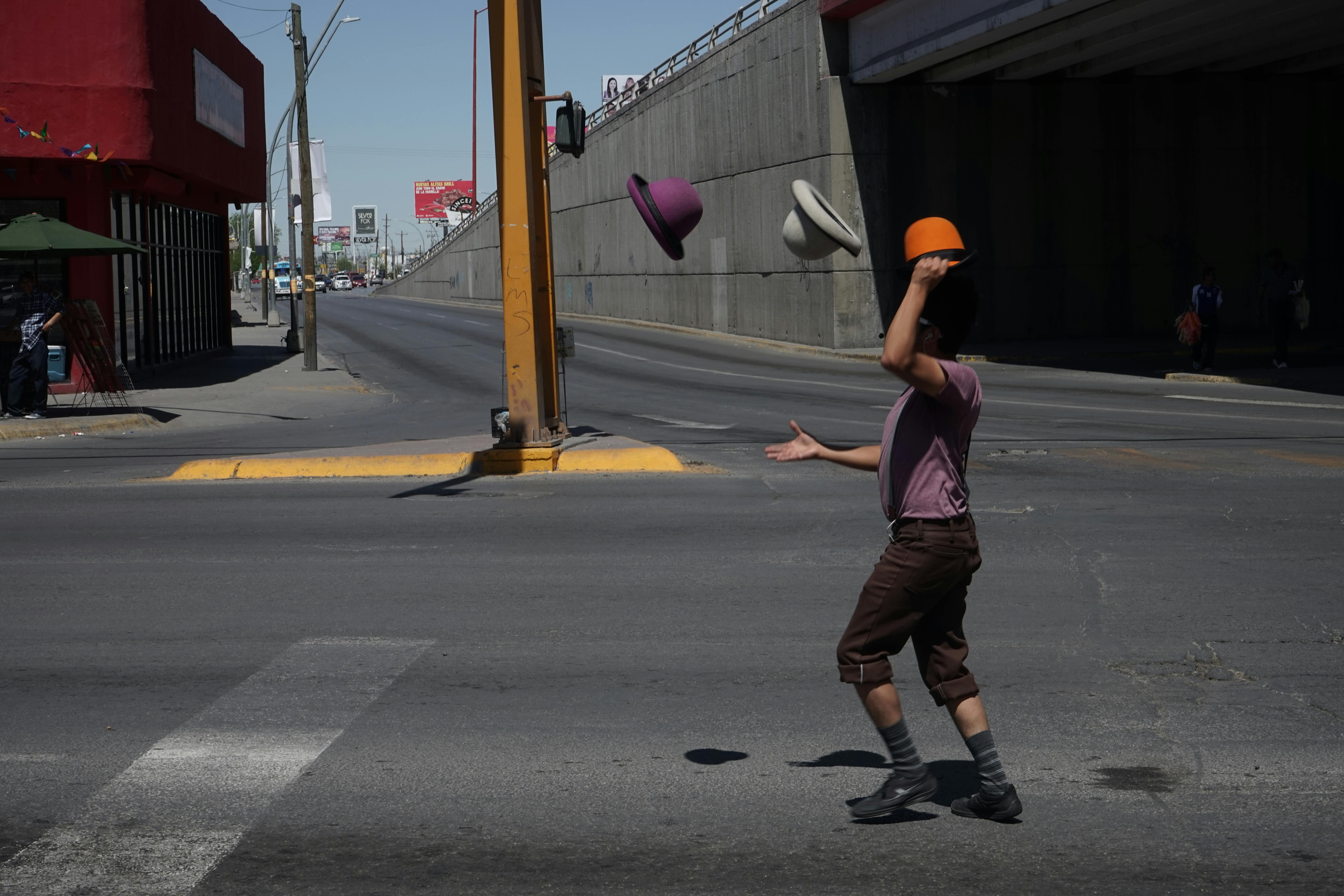 A Man Juggling Hats on the Street · Free Stock Photo