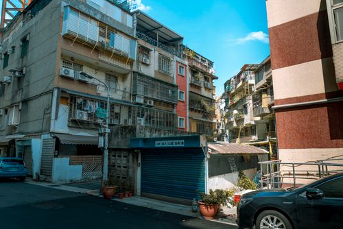 Free Street view of urban residential buildings with balconies and parked cars on a sunny day. Stock Photo