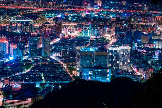 Stunning aerial view of a bustling city at night, illuminated by vibrant lights.