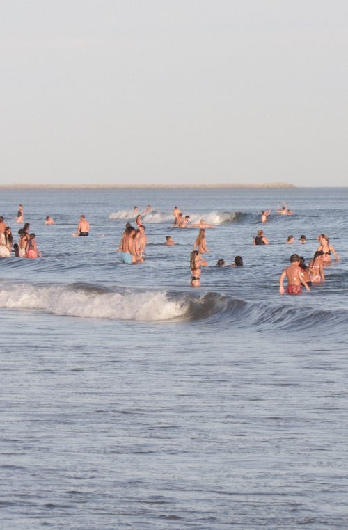 Photo of People Swimming on the Beach