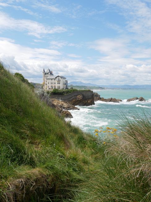 The picturesque Villa Belza perched on Biarritz's coastline with ocean waves and lush greenery.