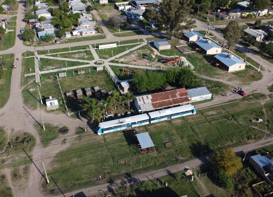 Aerial view of Cote-lai, Chaco, featuring a train and small town layout on a sunny day.