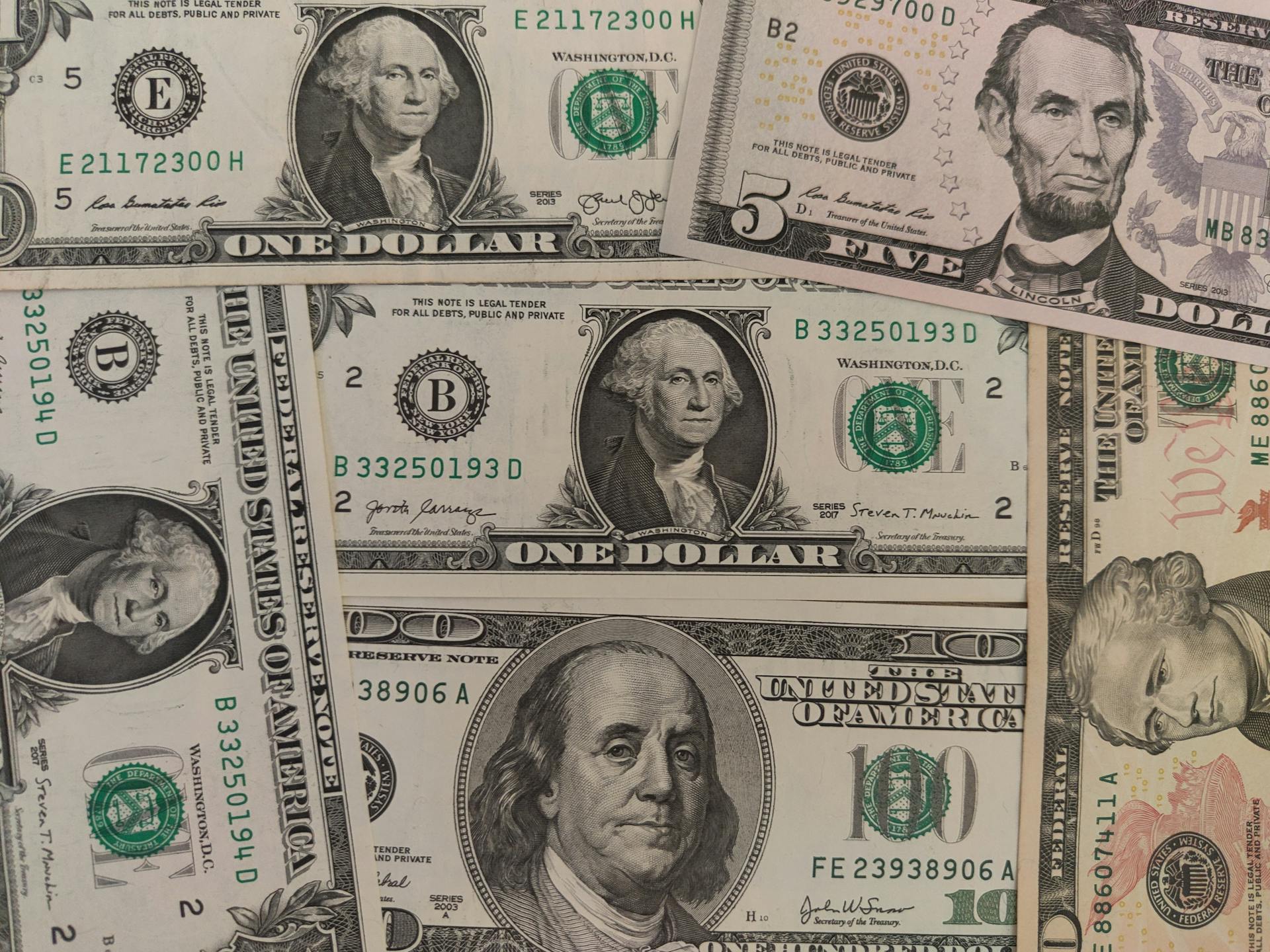 Close-up image showing a mix of U.S. dollar bills including $1, $5, and $10 bills.