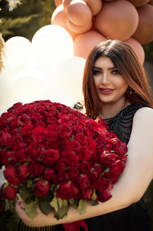 A Woman Holding Bouquet of Red Roses