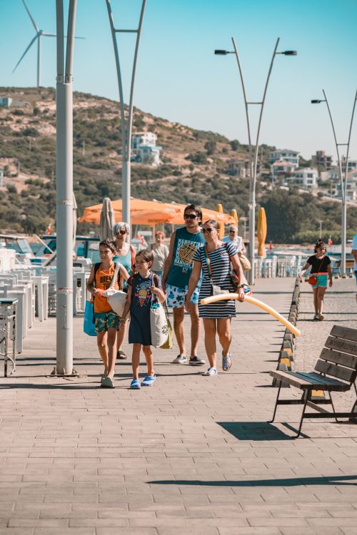Free A family enjoying a summer day walking along a scenic waterfront promenade. Stock Photo