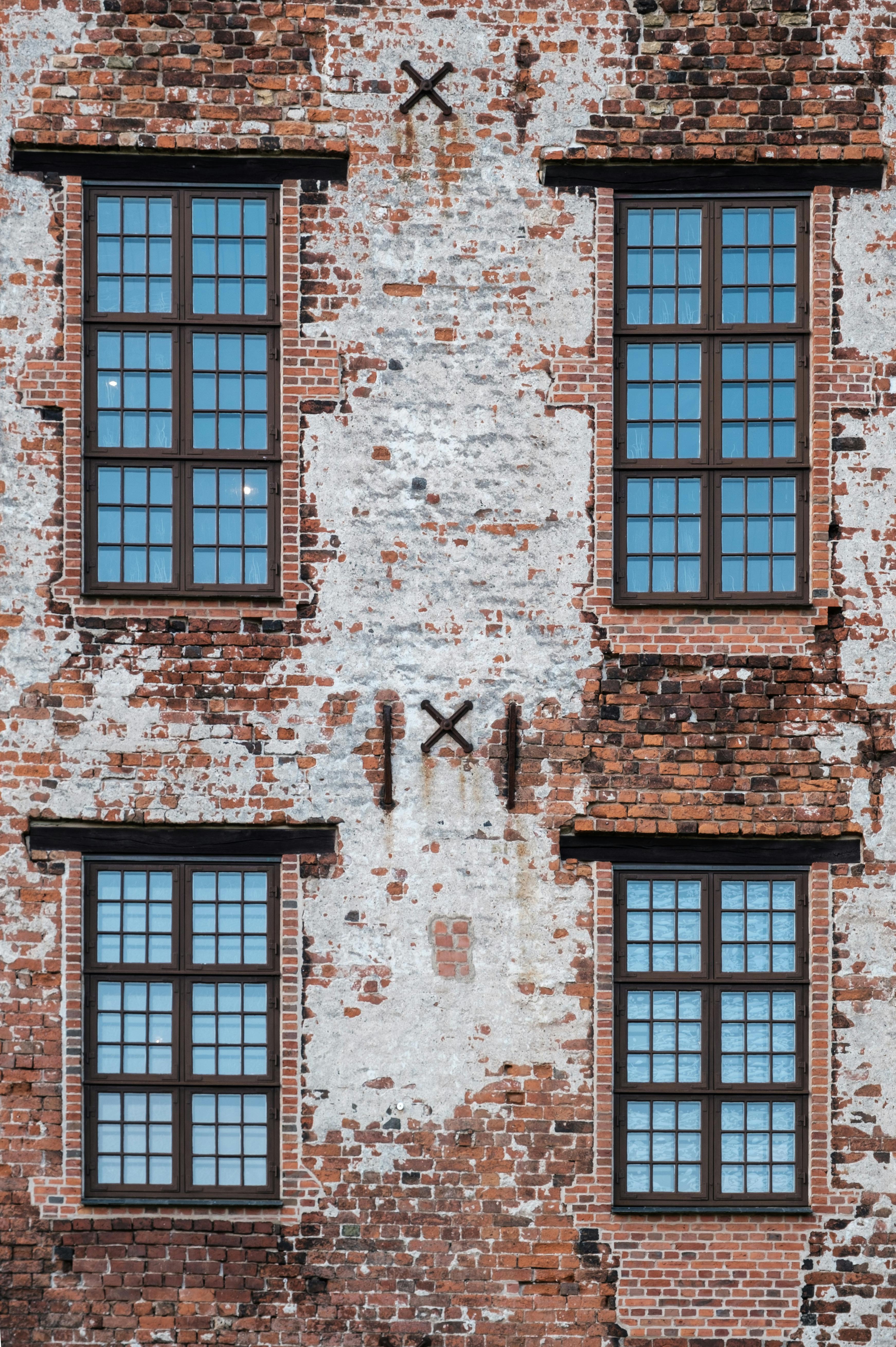 A detailed view of a historic brick building facade with classic windows in Kolding, Denmark.