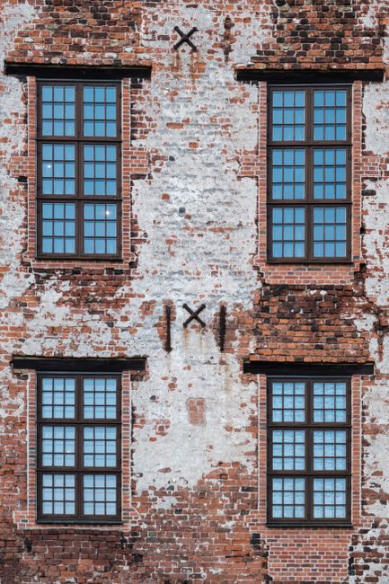 A detailed view of a historic brick building facade with classic windows in Kolding, Denmark.