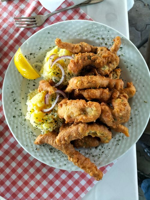Free Delicious plate of crispy fried chicken, mashed potatoes, and a lemon wedge on a checkered tablecloth. Stock Photo