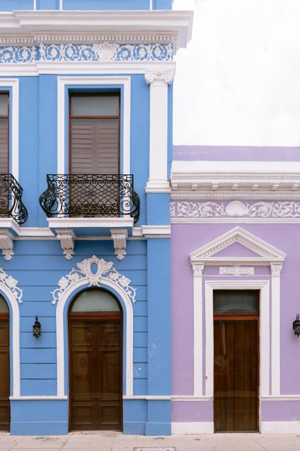 Vibrant blue and purple colonial buildings with ornate details in Mérida, Yucatán, Mexico.