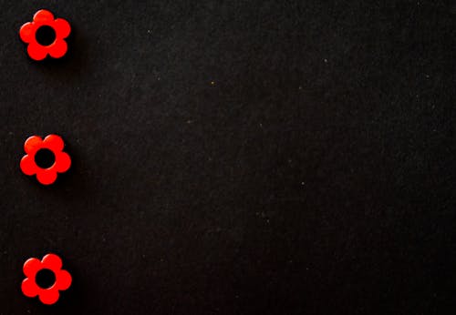 黑色表面上的三個紅色花珠