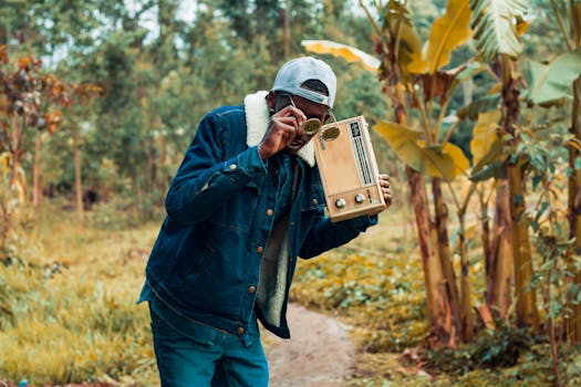 Stylish man with a retro radio in a lush forest setting in Kiambu, Kenya.
