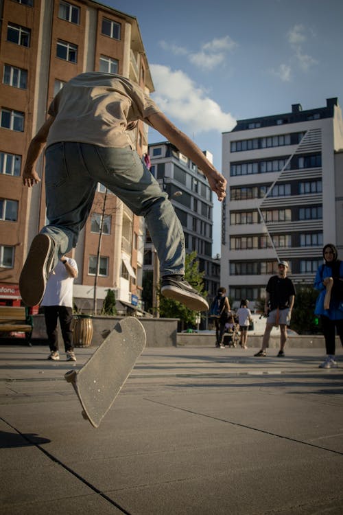 A Skater Riding a Skateboard Doing Tricks on the Street