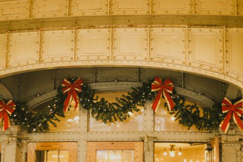 Free Elegant garlands and bows adorn a building entrance for Christmas celebration. Stock Photo