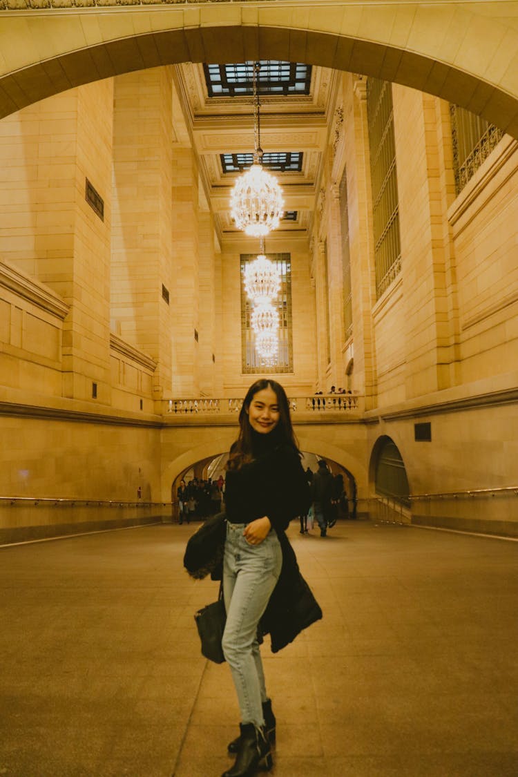 Brunette Woman Posing In A Monumental Building Hall With Chandeliers