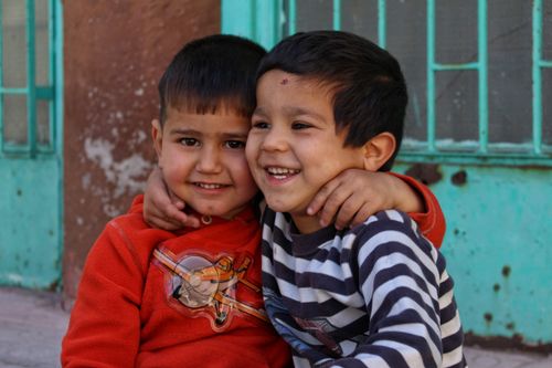 Free Two joyful boys sharing an embrace in colorful outdoor setting, Kayseri, Türkiye. Stock Photo