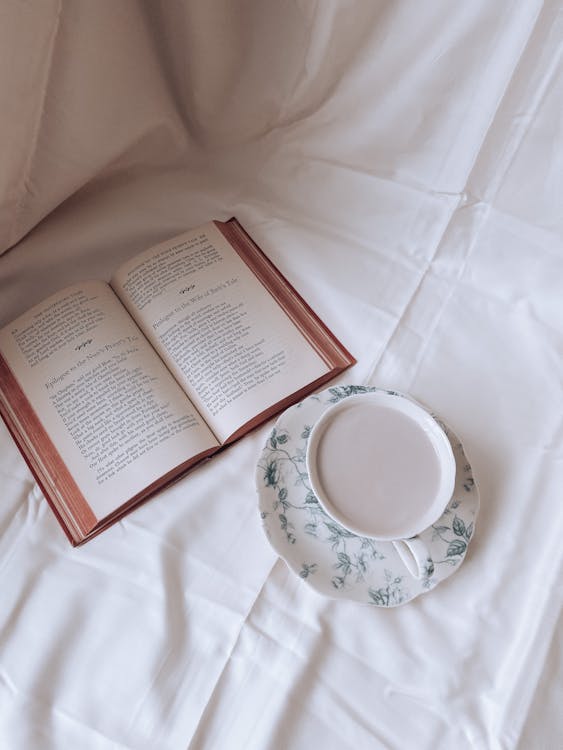 Cup and Saucer Beside an Open Book · Free Stock Photo