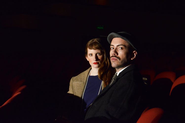 Man And Woman Seated On Theatre Seats 