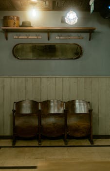 Vintage wooden seating against a paneled wall with warm lighting and reflective decor in İstanbul.