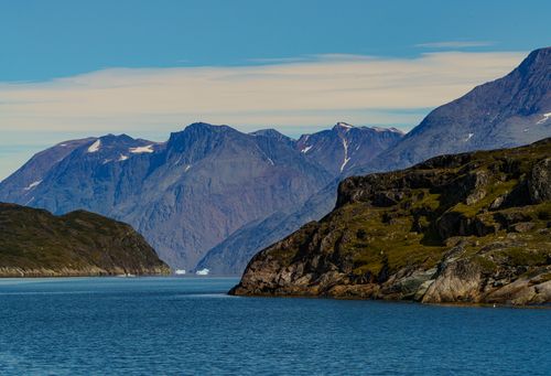 Free Dramatic rocky coastline and towering mountains in Nuuk, Greenland under a bright blue sky. Stock Photo