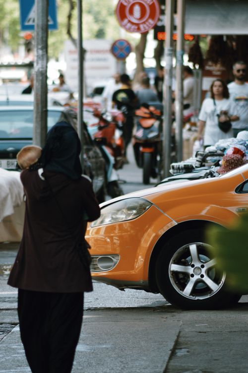 Free Dynamic urban shot with pedestrians and an orange car on a busy street. Stock Photo