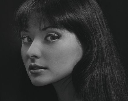 Black and white portrait of a woman with a retro and elegant appearance.