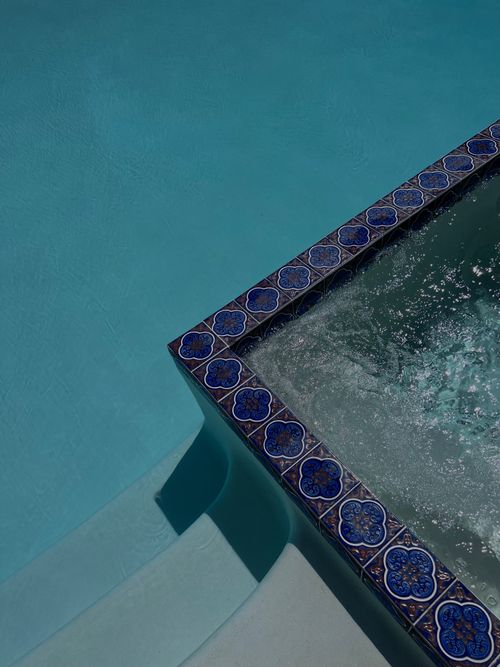 Free High angle view of a swimming pool with intricate blue tiles and water ripples. Stock Photo