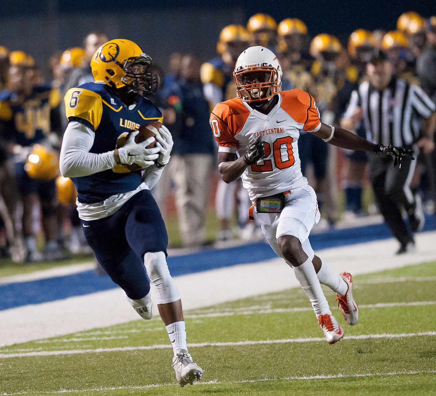 Dynamic photo of high school football game with players in motion during intense play.