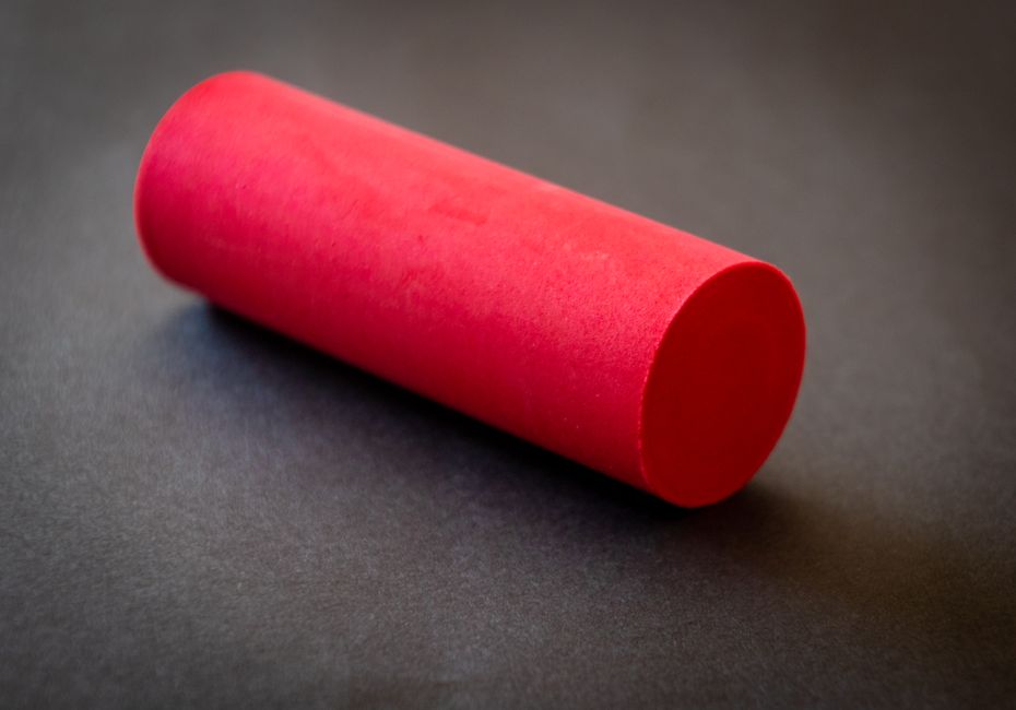 Striking red cylinder against a dark background, perfect for abstract themes.