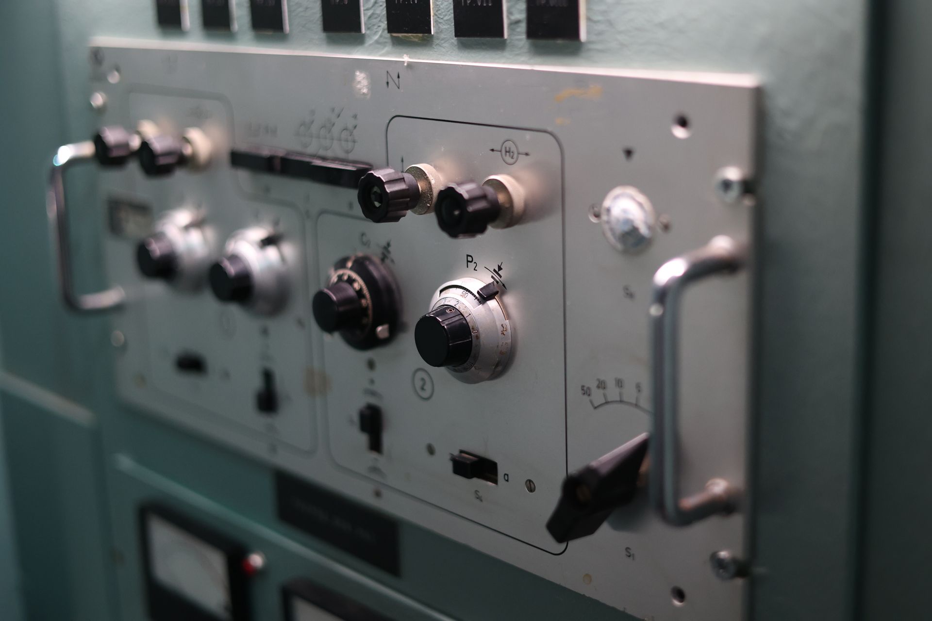 Detailed view of switches and dials on an industrial control panel, showcasing engineering complexity.