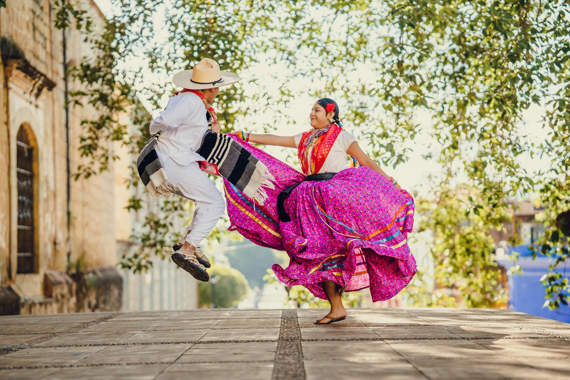 People Dancing on City Street Wearing Traditional Clothing