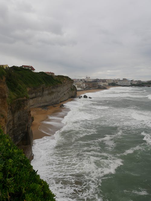 Green and Brown Cliff Beside Body of Water