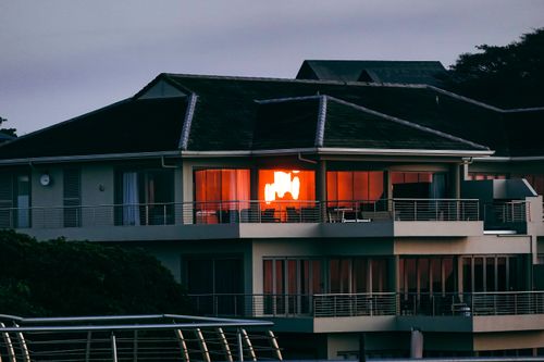 Free Elegant modern house on Dolphin Coast, South Africa, reflecting the warm glow of the sunset. Stock Photo