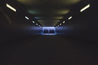 隧道光线昏暗，荧光灯照亮了通往出口楼梯的路，营造出戏剧性的视角